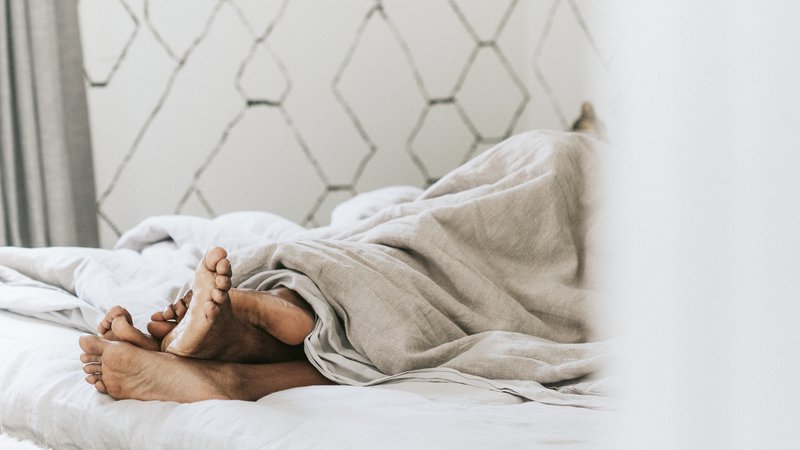 Black couple with their feet under the blanket